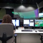 woman in front of several monitors doing an automation test