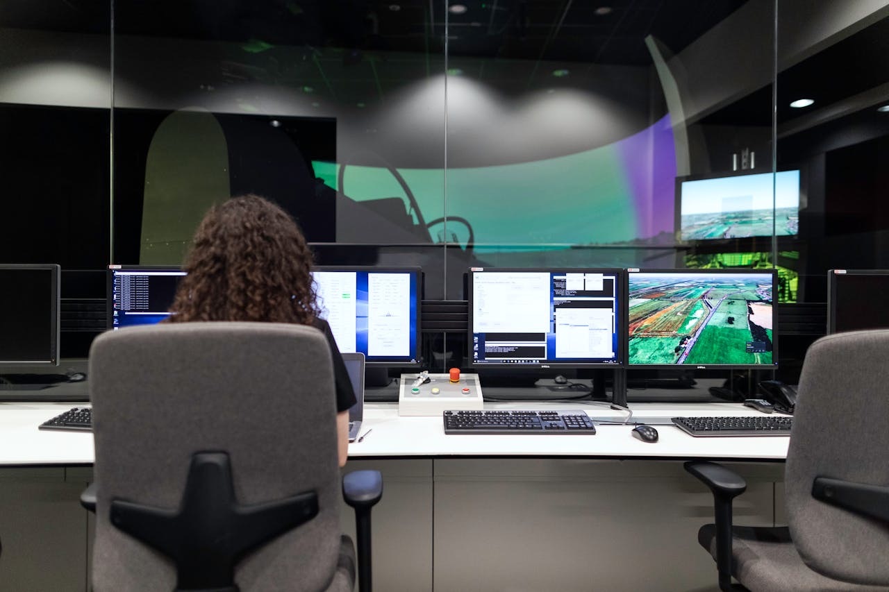 woman in front of several monitors doing an automation test